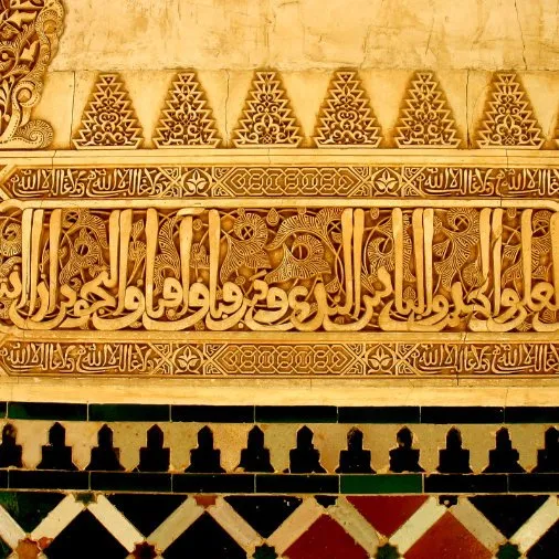 Un mur sculpté de calligraphies et de motifs dorés