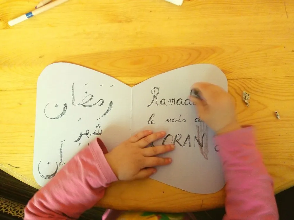 Un petit livre en papier avec un verset recopié en arabe