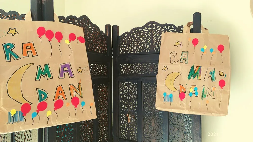 Des sacs en papier décorés de gommettes, avec le mot Ramadan
